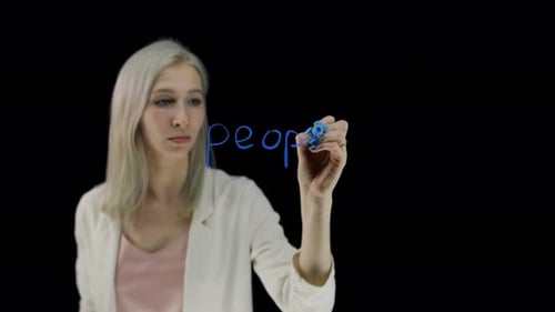 The Word Peoplekind The Girl Writes with a Blue Marker Clear Glass in the Classroom