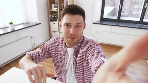 Smiling Man Talking To Camera Indoors