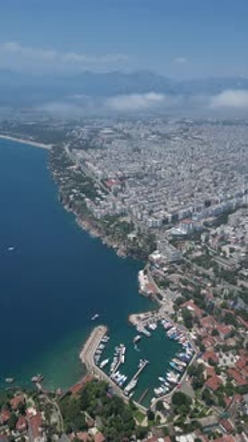 Aerial video high above the coastline and a small marina in the city of Antalya Turkey
