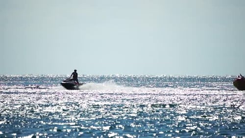 Jet Ski Pulling Raft on Sparkling Blue Ocean