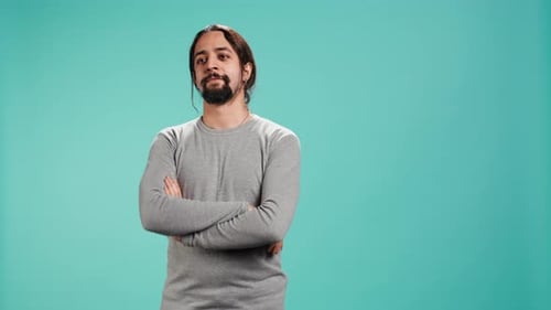 Man Smiling with Arms Crossed in Front of Blue