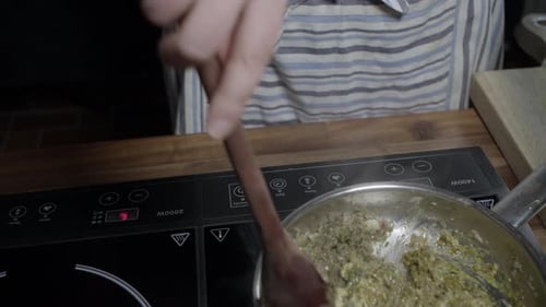 A chef mixing ingredients in a metal pan. Preparing delicious café de paris sauce for steaks. No fac