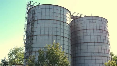 A pair of grain silos - aerial view in sunny day. Close-up of agricultural silos.
