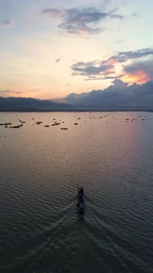Aerial View of Boat Sailing on Water at Sunset