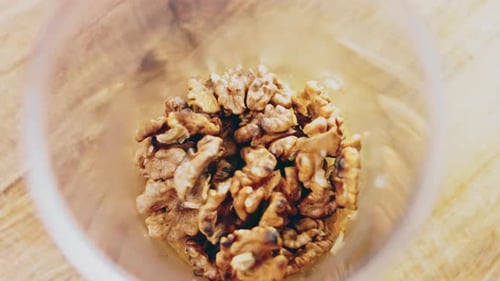 Walnuts Being Poured Into a Clear Bowl