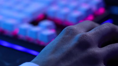 Mano joven haciendo clic fuera del marco del ratón. Gamer, streamer, joven adulto iluminado en azul, pantalla en
4k