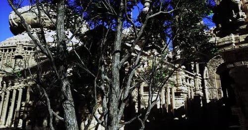 Ancient Temple Ruins Surrounded By Trees Under a Clear Blue Sky