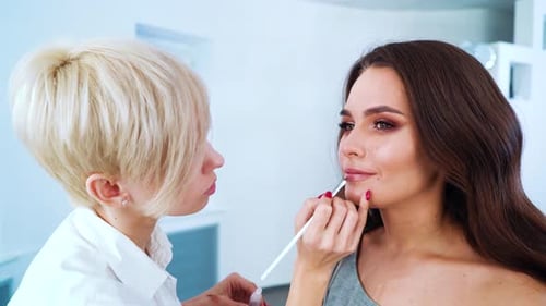 Makeup Artist Applying Lip Liner in Studio Setting
