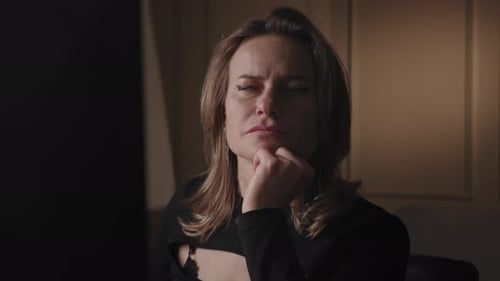 Thoughtful Woman in Black Shirt Sitting and Thinking with Hand on Chin Indoor Setting