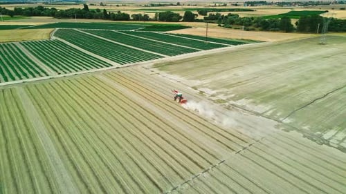 Tractor Working in a Field Surrounded by Farmlands - Aerial View 4K