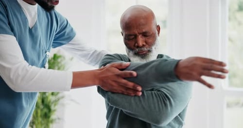 Therapist Stretching Arm of Senior Man