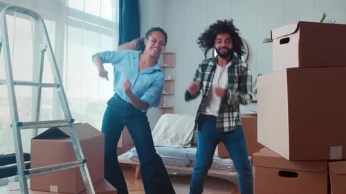Cheerful Couple Dancing in New Home After Moving