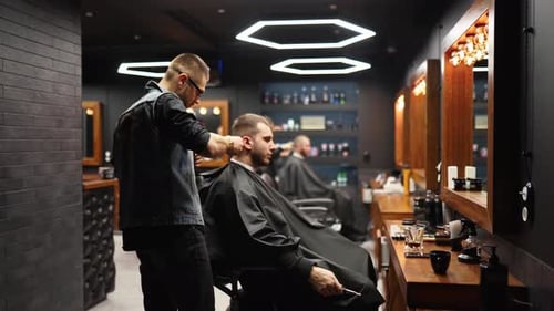 Barber Trims Customer's Hair in Stylish Barbershop
