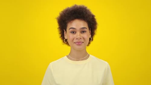 Young Woman Smiling in Front of Yellow Background