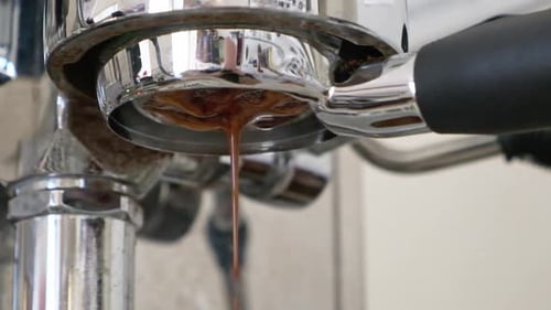 Espresso flowing out closeup from a bottomless filter