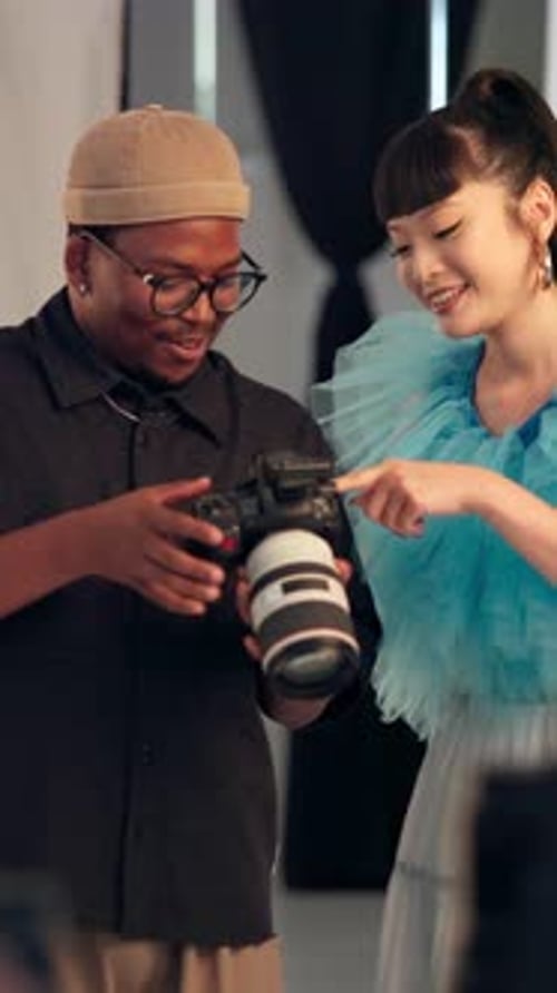 Cameraman, model and talking to woman in studio for photography, show picture or fashion production
