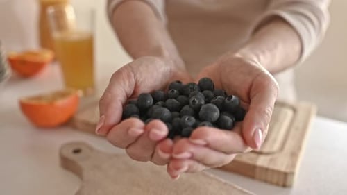 Adult Hands Holding Fresh Blueberries Close Up