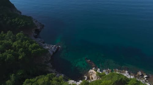 Aerial Video of a Beautiful Seaside Landscape With Green Trees Rocky Beaches and Sparkling Azure