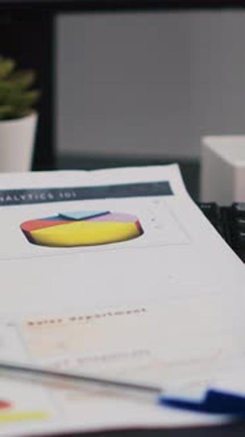 Vertical Video Company Files Containing Economic Graphs and Charts Near Coffee Cup Close Up