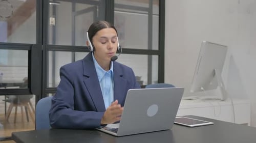 Hispanic Woman with Headset Talking with Customer in Call Center