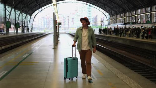 Young Adult Walking with Suitcase in Train Station