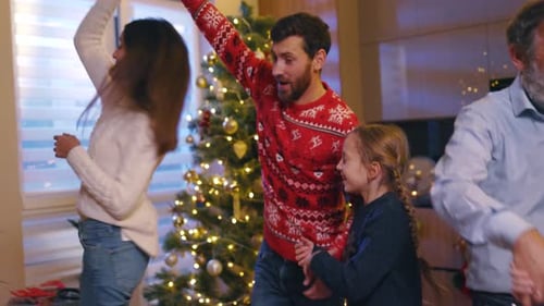 Family Dancing Together near Christmas Tree in Home