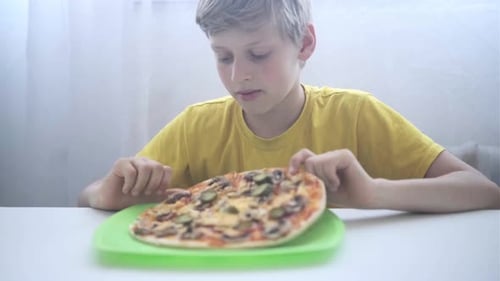 Boy Looks at Pizza on a Plate