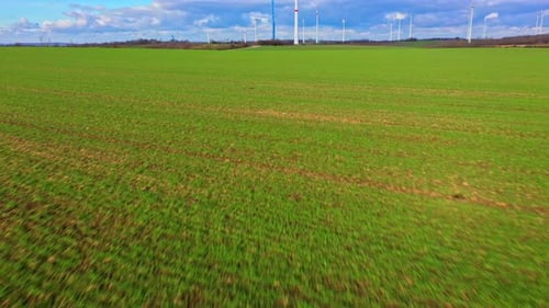 Ombre d'un Drone survolant un champ vert près du site d'assemblage d'un parc éolien par une journée ensoleillée. Révélation inclinable