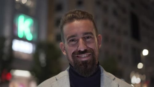 Successful Caucasian Man Looking at Camera Smiling Standing at Night with a City Background