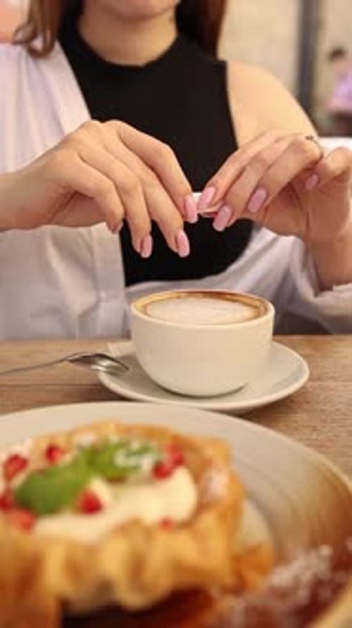 A girl drinking delicious coffee with milk in a cafe