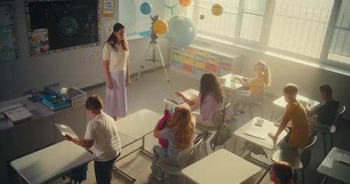 Female Teacher Greeting Group of Diverse Kids at the Beginning of School Day