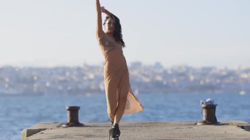 A Woman is Dancing on a Dock By the Water