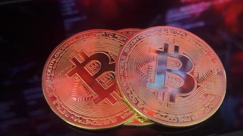 Golden Bitcoins Shimmering with Blue and Red Lights