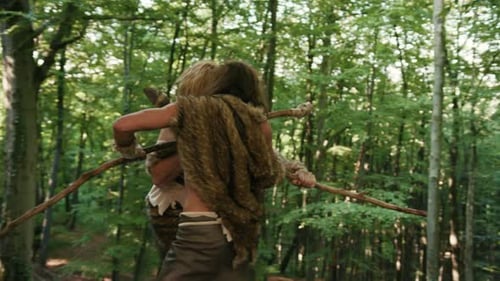 Una escena de un hombre primitivo enfrascado en feroces combates en lo profundo de un denso bosque