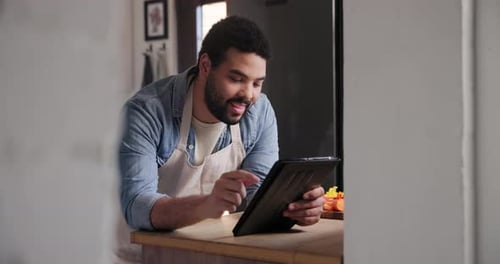 Man Uses Tablet in Bright Kitchen
