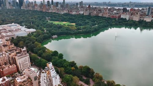 Beautiful view of Central Park in New York. Green zone with lake surrounded by building. Top view.