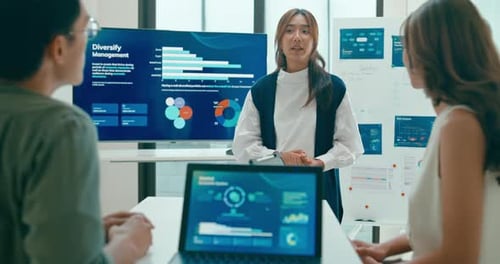 Group of Asian businesspeople work together leads business meeting uses presentation TV in office.