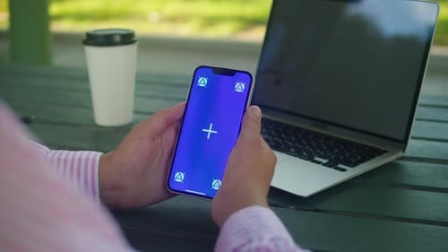 Woman Hand Holding Phone with Chroma Key Screen Outdoor Smartphone with Green Screen Closeup