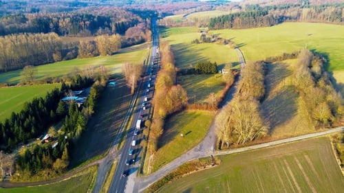 Aerial View of a Serene Country Road Flanked by Lush Fields and Trees