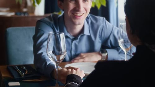 Cheerful Man Checking Menu during Date with Girlfriend in Restaurant