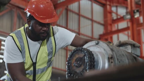 Engineer or operator wearing a safety suit maintaining machine in the industrial factory