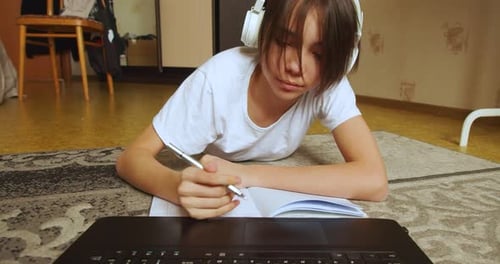 Teenager Studying with Laptop and Notebook