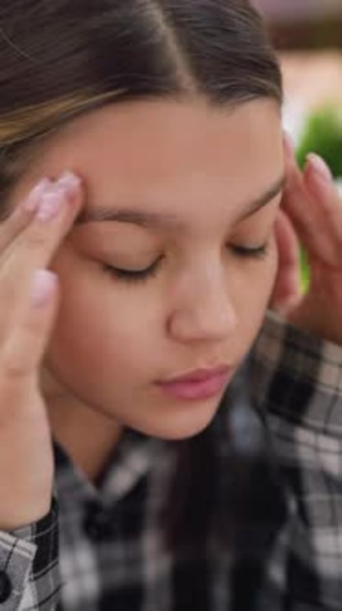Teen Girl Massaging Face in Vertical Close Up