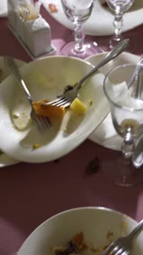 leftovers on white dishes are on the festive table. Camera motion forward Vertical video