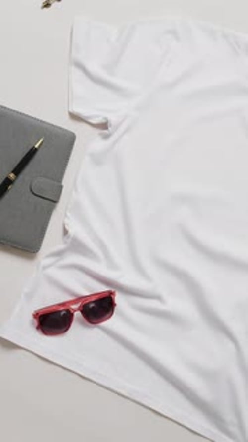 Video of orange t shirt, denim trousers, sunglasses and copy space on white background