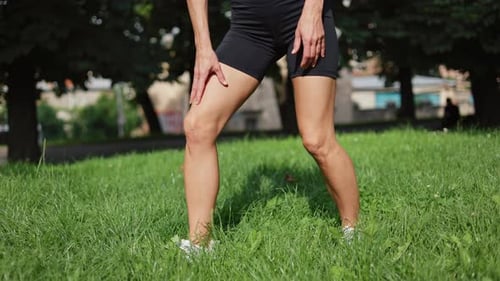 Close Up of Woman in Black Shorts Massaging Knee Because of Pain After Sport
