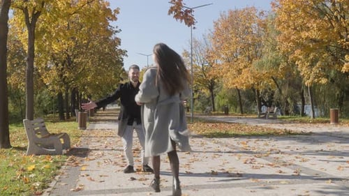 Woman Running to Man for Hug in Autumn Park