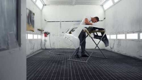 Professional repairman in garage works with automobile parts