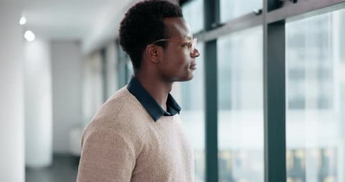 Young Adult Looks Out Window in Office