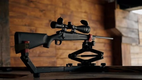 Closeup Professional Shooting Range on Wooden Table Stands Professional Rifle with Largecaliber